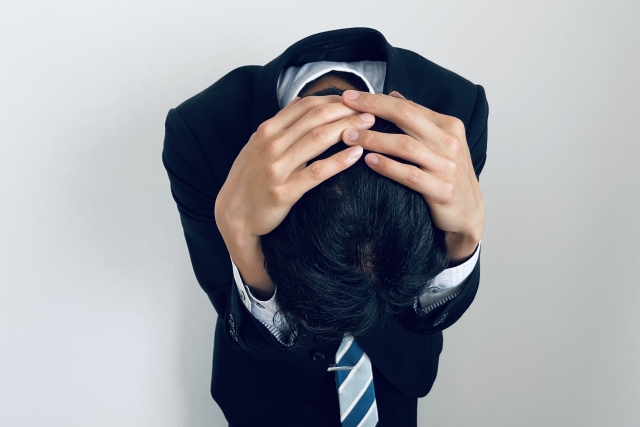 頭を抱えている男性