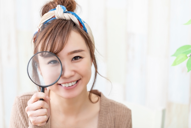虫眼鏡を構える女性