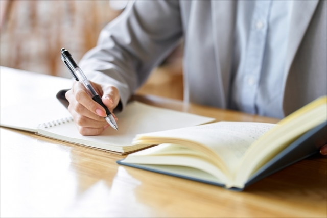 ノートに何かを書こうとしている人