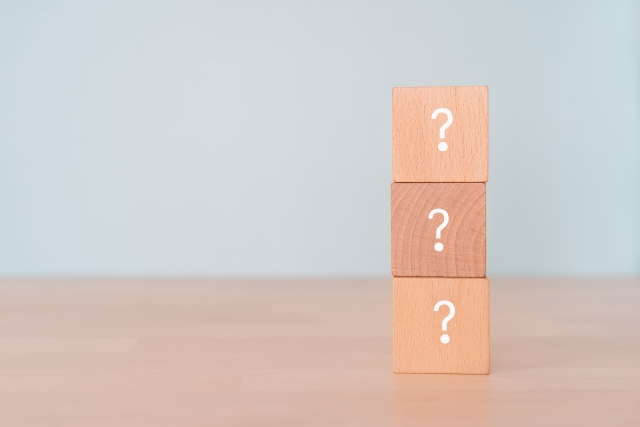 はてなマークが書かれた木のブロックが縦に3つ重なっている