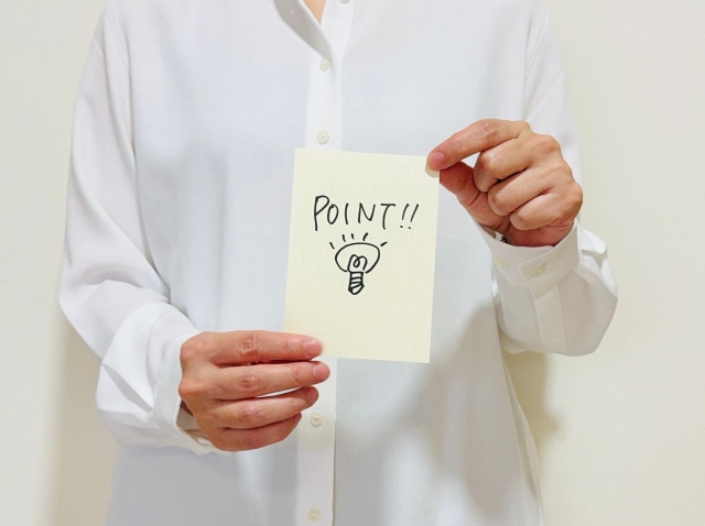 POINTと書かれた紙を持つ人