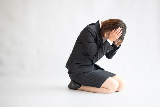 跪いて頭を抱える女性
