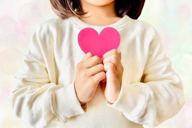 ハート形の紙を持つ少女